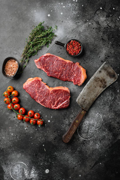 istock Raw marbled beef steaks, on black dark stone table background, top view flat lay, with copy space for text 1367157866