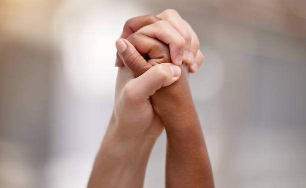 Shot of two people united and holding hands at a protest Bonded by a heartfelt cause anonymous activist network stock pictures, royalty-free photos & images