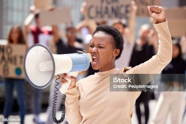 Shot Of A Young Woman Shouting Through A Loudhailer At A Protest Stock Photo - Download Image Now