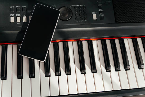 istock Smartphone on musical synthesizer keyboard. Smartphone on electronic piano. 1367159267