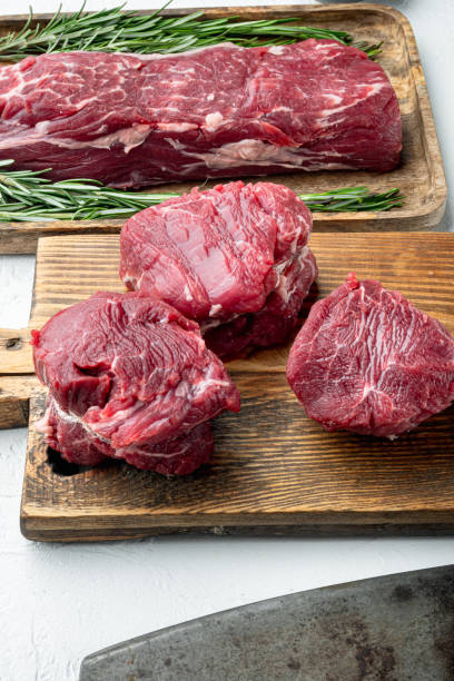 istock Raw beef fillet steaks with spices, on wooden cutting board, on white stone  surface 1367159651