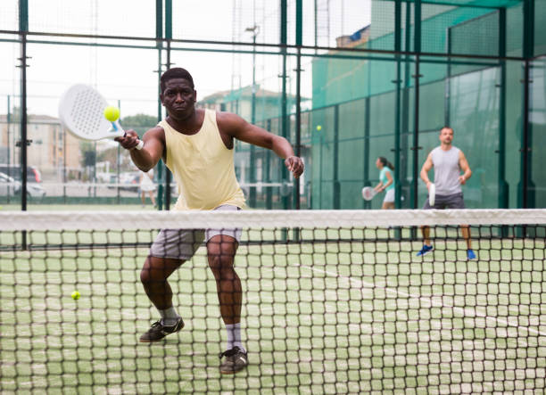 istock Young adult men playing doubles paddle tennis 1367160700