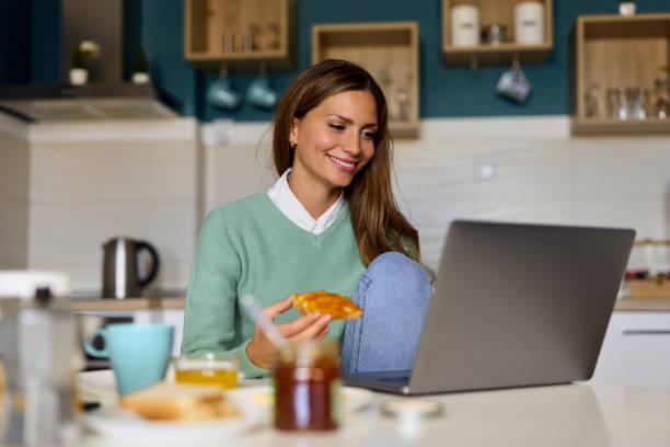 istock Young woman making a video call on her laptop during breakfast 1367160801