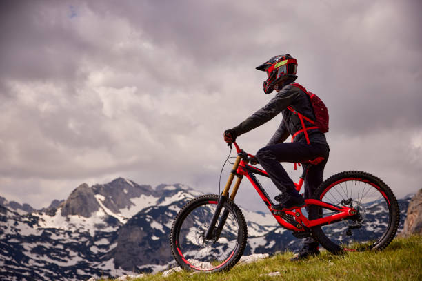 istock Male mountain biker looking at beautiful mountain landscape 1367161293