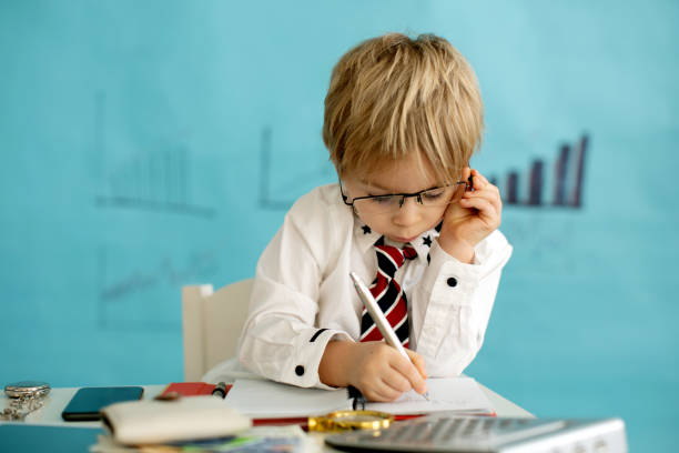 istock Good looking, smart casual dressed child, blond boy with tie, working on tablet, taking notes and talking on the phone, business concept 1367162960