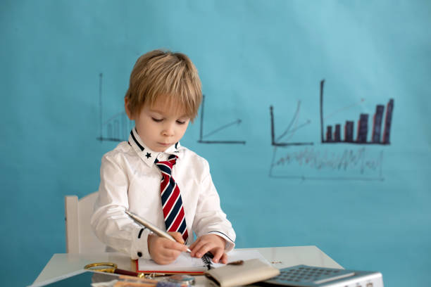 istock Good looking, smart casual dressed child, blond boy with tie, working on tablet, taking notes and talking on the phone, business concept 1367163011