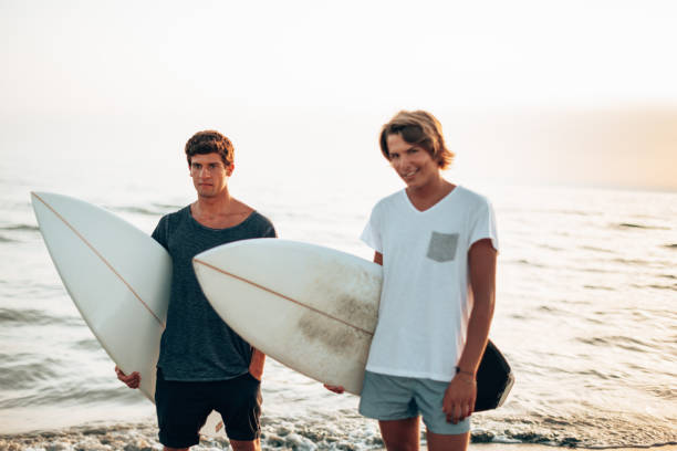 istock young people run on the beach with surfboard 1367164181