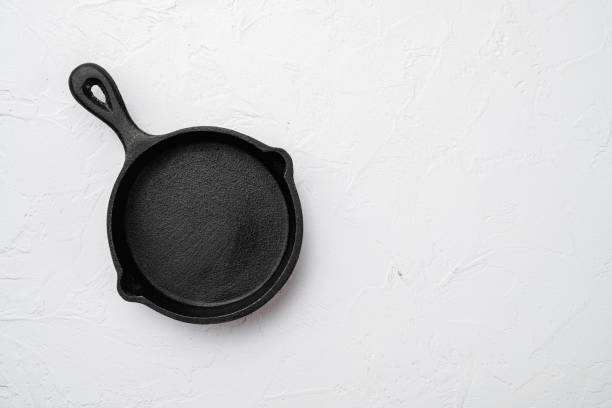 istock Used old empty frying pan with copy space for text or food with copy space for text or food, top view flat lay , on white stone table background 1367169484