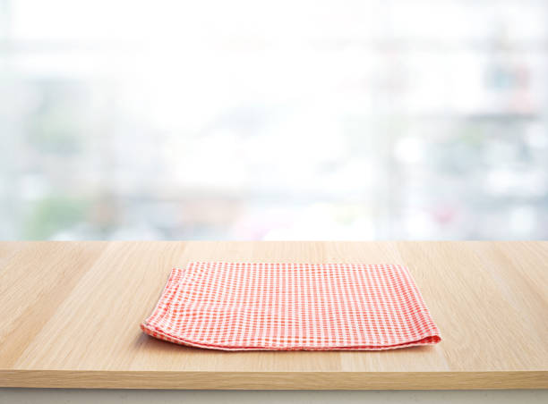 istock Red checked tablecloth on wood with blur home window background. 1367169913