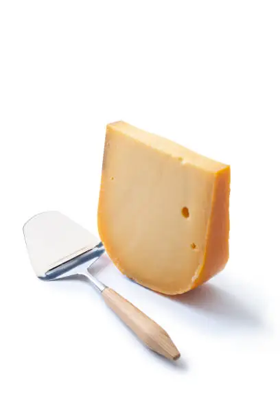 One Piece of Dutch Gouda cheese with a cheese-slicer, isolated on a white background