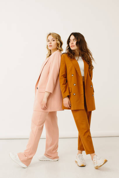 stylish young women in pastel outfits standing together, fashion concept - stock photo - mode bildbanksfoton och bilder