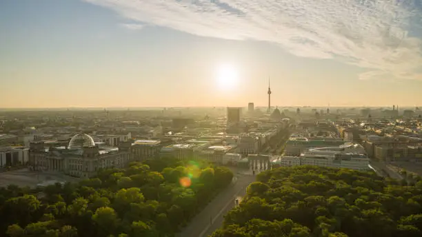 The Reichstag building and the Brandenburg Gate in Berlin in the summer sunrise at the Golden Hour. In the background the Hotel Adlon and the Berlin TV Tower.