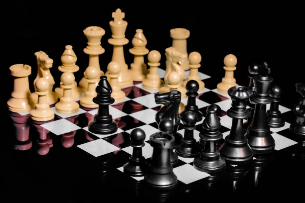 istock Close up of Chess pieces on a reflective mirror board surface with black background 1367185844