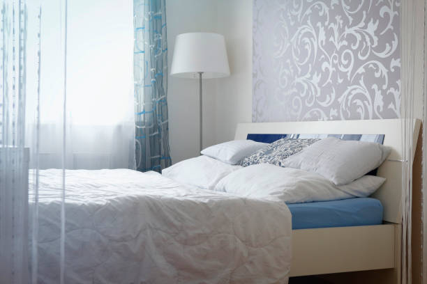 Bright and modern bedroom with a floral-patterned accent wall, minimalist furniture, and airy ambiance