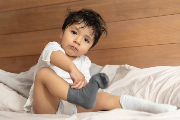 istock Mexican 2 years old baby putting on socks wrong 1367186972
