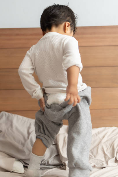 istock Mexican 2 years old baby putting on socks wrong 1367187007