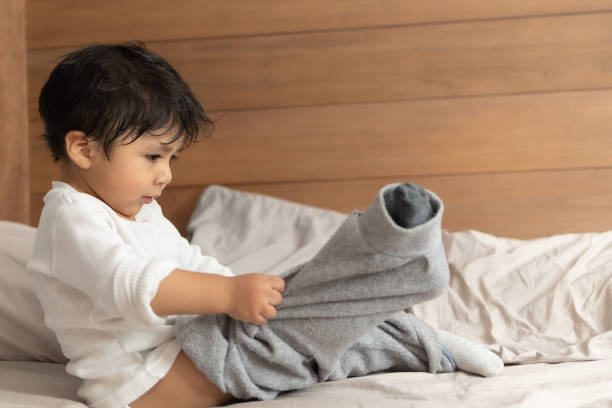 Mexican 2 years old baby putting on socks wrong Mexican 2 years old baby putting on socks wrong getting dressed stock pictures, royalty-free photos & images