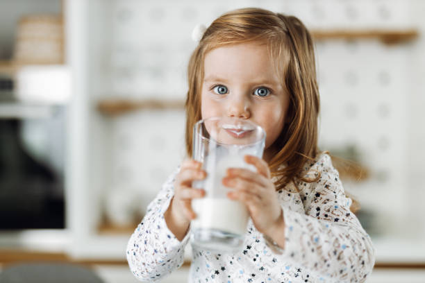 istock Little girl drinking fresh milk from a glass 1367188113