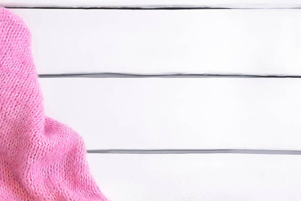 istock Pink warm knitted plaid on white wooden table with copy space. Flat lay 1367188391