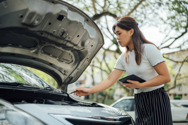 an asian insurance adjuster inspecting damage to vehicle - car insurance insurance agent damaged imagens e fotografias de stock