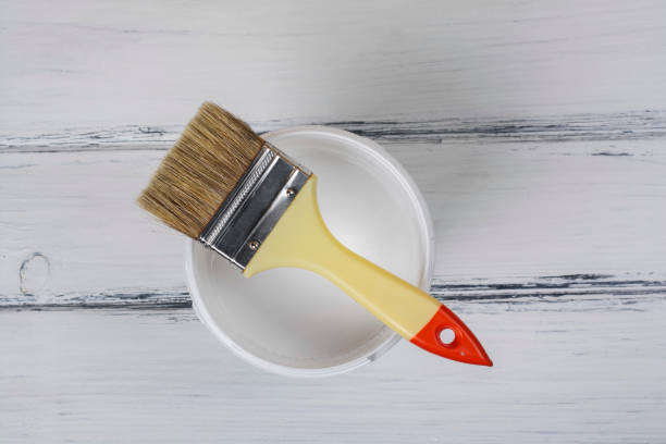 istock A can of paint and a brush on the table. View from above. 1367189975