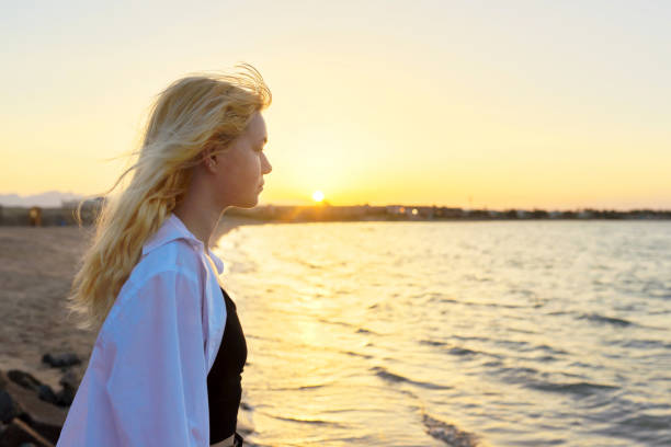 istock Sea sunset, young woman looking at horizon sun, copy space 1367191772