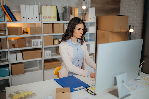 Woman is working at warehouse for online seller. Concept of small web business.