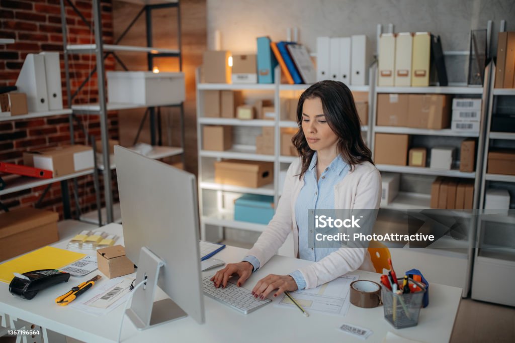 Woman is working at warehouse for online store. Woman is working at warehouse for online seller. Concept of small web business. Owner Stock Photo