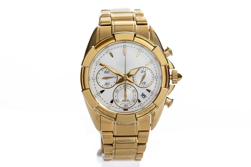 golden women's wrist watch with diamonds and a metal bracelet and chronograph isolated on a white background close-up. Expensive and rich gift for women. High quality photo