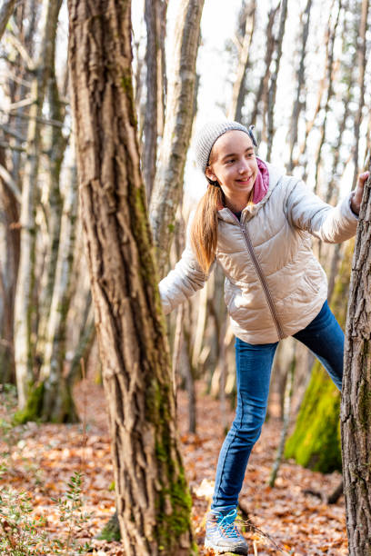 istock Girl in the Winter Forest Playing with the Tree 1367200092