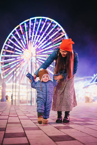 mãe e filho no parque de diversões - blurred motion clothing mother offspring - fotografias e filmes do acervo