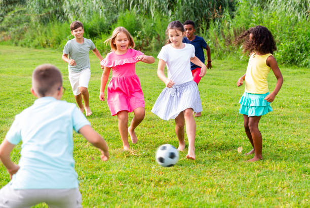 istock Cheerful tween friends playing with ball outdoors in summer 1367201384