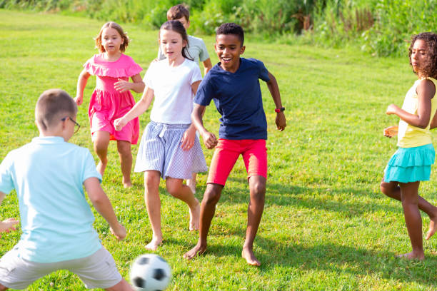 istock Active tweenagers playing football on green grass in summertime 1367201397
