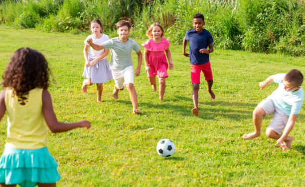 istock Cheerful tween friends playing with ball outdoors in summer 1367201398