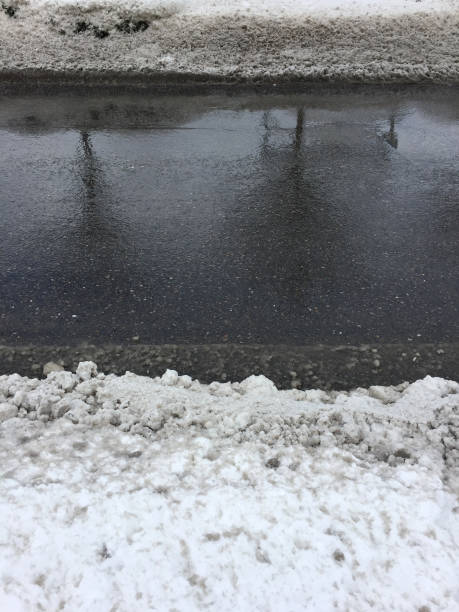 istock Wet asphalt road and snowy sidewalk 1367201405