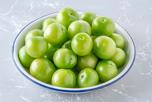 ripe and fresh green plum fruits on the table
