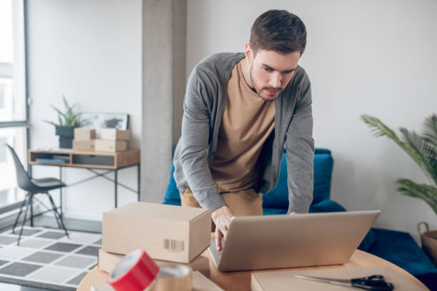 istock Concentrated online store employee working on the portable computer 1367203428