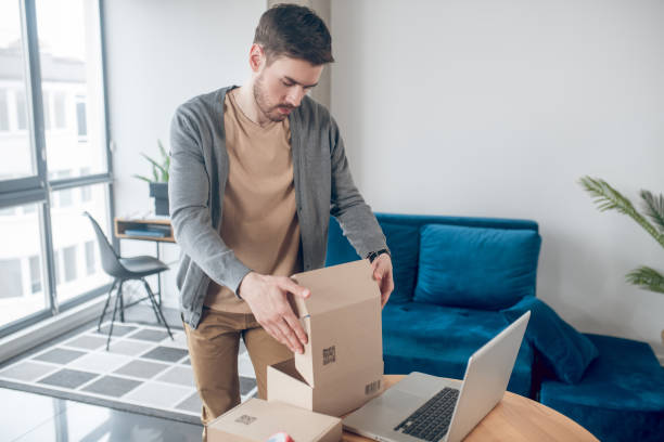 istock Concentrated Internet shop worker packing goods for shipping 1367203557