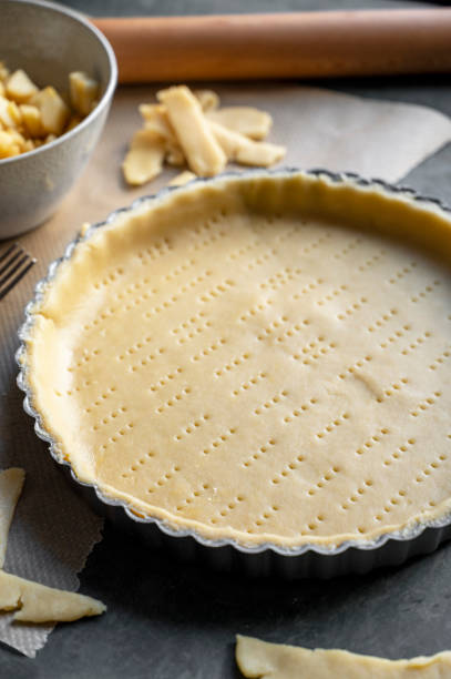 istock Homemade pie crust in pie plate. Cooking apple pie, dark background. 1367204602