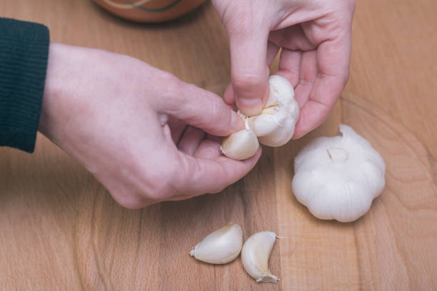 vorbereitung knoblauch - schälen essen zubereiten stock-fotos und bilder