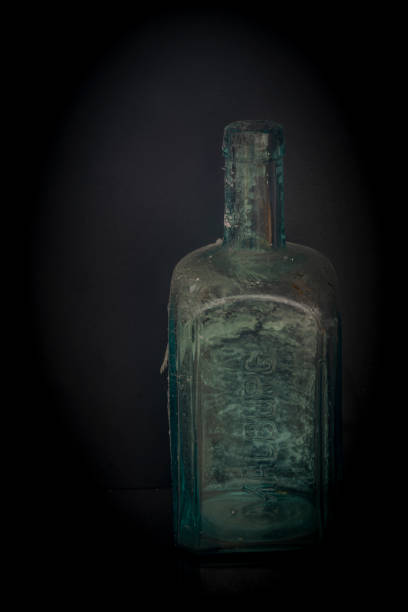 istock Black background and glass bottles with reflection on table 1367205705