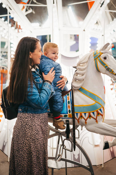 Mom with a cheerful baby on a carousel