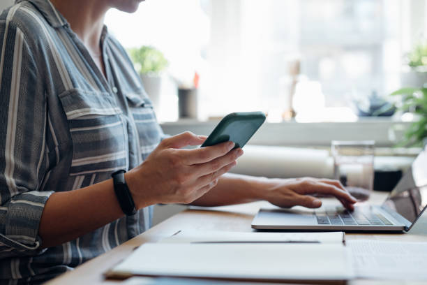 istock Anonymous Young Businesswoman Using a Smartphone While Working From Home 1367206867