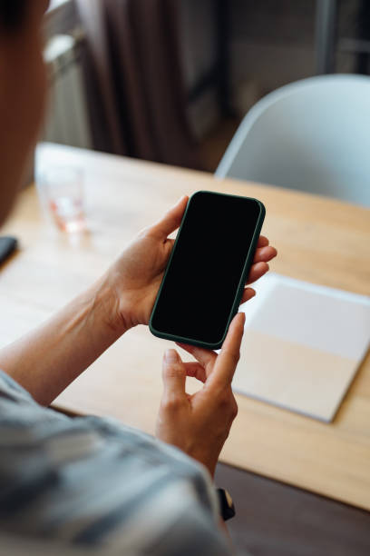 istock Anonymous Young Businesswoman Holding a Smartphone 1367206879