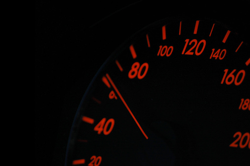 Speedometer close up over a black background.