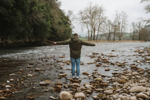 istock Man balancing on top of a rock in a river 1367210977