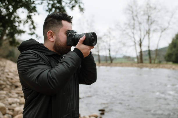 istock Photographer taking a photo of a river 1367211002
