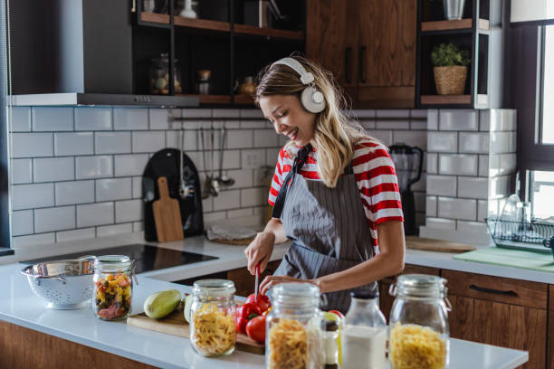 istock Young woman preparing meal in the kitchen 1367211199