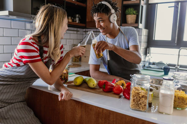 istock Friends having fun and cooking together in the kitchen 1367211218