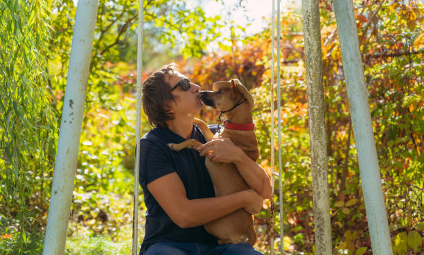 istock A man kisses a dog on the lips. 1367212174